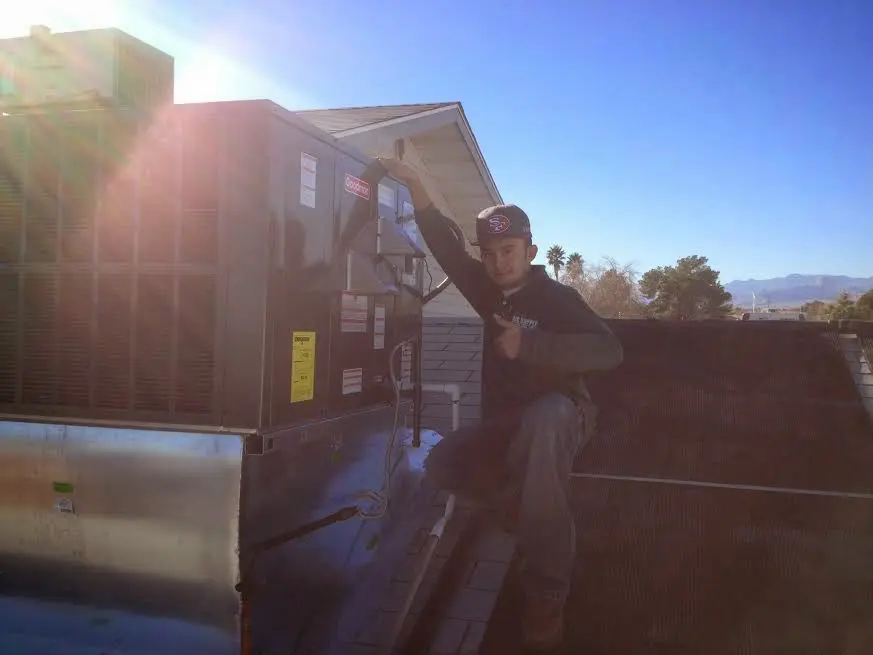 HVAC technician performing AC Tune-Up on a rooftop unit in Happy Valley